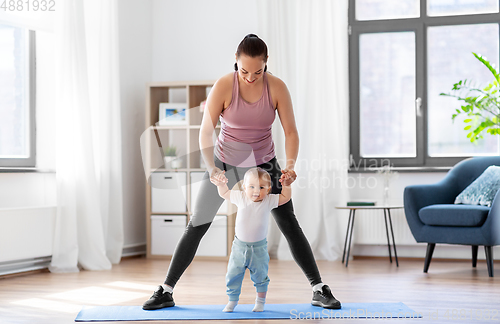 Image of happy mother with little baby exercising at home