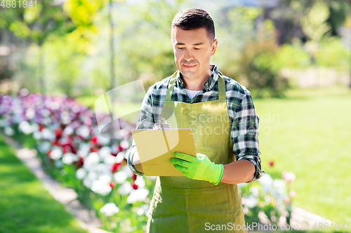 Image of happy man with clipboard at summer garden