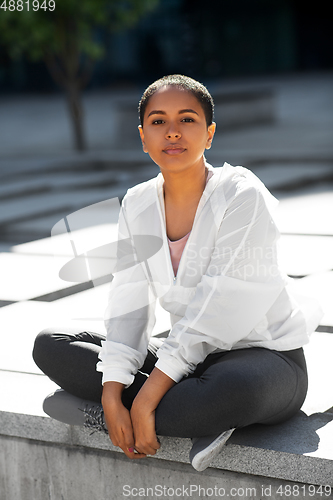 Image of african american woman in sports clothes outdoors