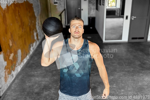 Image of young man with medicine ball in gym