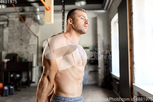 Image of young man with bare torso in gym