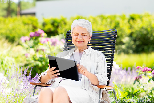 Image of happy senior woman with tablet pc at summer garden