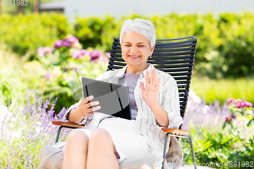 Image of happy senior woman with tablet pc at summer garden