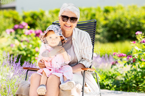 Image of happy grandmother and baby granddaughter at garden