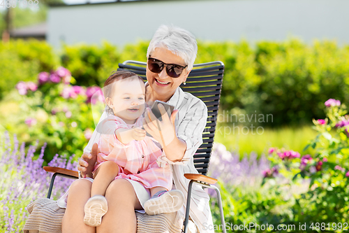 Image of grandmother and baby granddaughter with phone