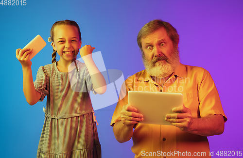 Image of Senior man, grandfather having fun and spending time together with girl, granddaughter. Joyful elderly lifestyle concept