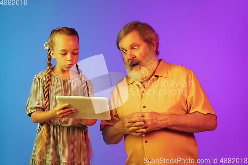 Image of Senior man, grandfather having fun and spending time together with girl, granddaughter. Joyful elderly lifestyle concept
