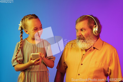 Image of Senior man, grandfather having fun and spending time together with girl, granddaughter. Joyful elderly lifestyle concept