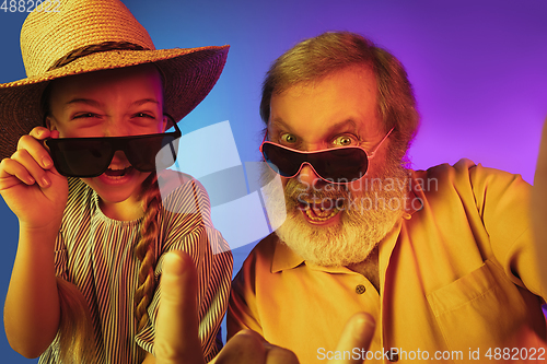 Image of Senior man, grandfather having fun and spending time together with girl, granddaughter. Joyful elderly lifestyle concept