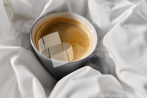 Image of cup of coffee in bed