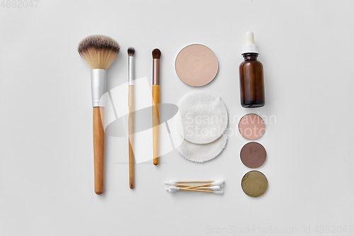 Image of make up brushes, cosmetics and cotton swabs