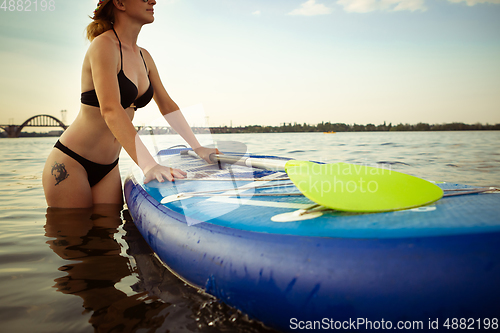 Image of Young attractive woman carries paddle board, SUP. Active life, sport, leisure activity concept