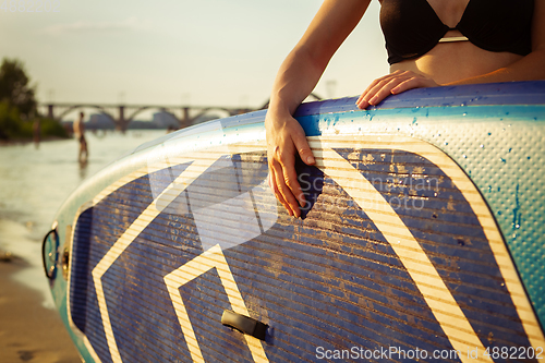 Image of Young attractive woman carries paddle board, SUP. Active life, sport, leisure activity concept