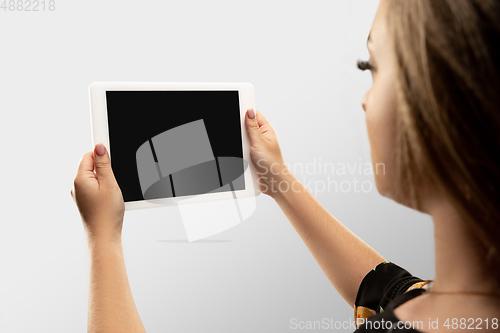 Image of Close up female hands holding tablet with blank screen during online watching of popular sport matches and championships all around the world. Copyspace for ad