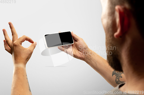 Image of Close up male hands holding phone with blank screen during online watching of popular sport matches and championships all around the world. Copyspace for ad