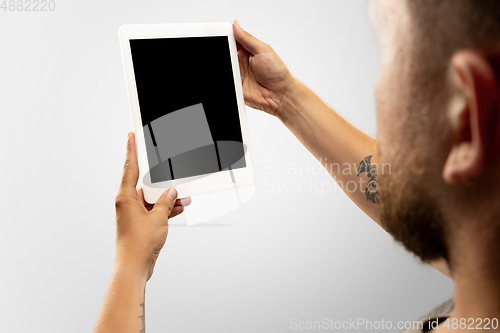 Image of Close up male hands holding tablet with blank screen during online watching of popular sport matches and championships all around the world. Copyspace for ad