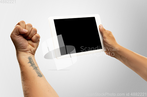 Image of Close up male hands holding tablet with blank screen during online watching of popular sport matches and championships all around the world. Copyspace for ad