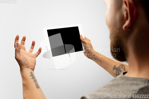 Image of Close up male hands holding tablet with blank screen during online watching of popular sport matches and championships all around the world. Copyspace for ad