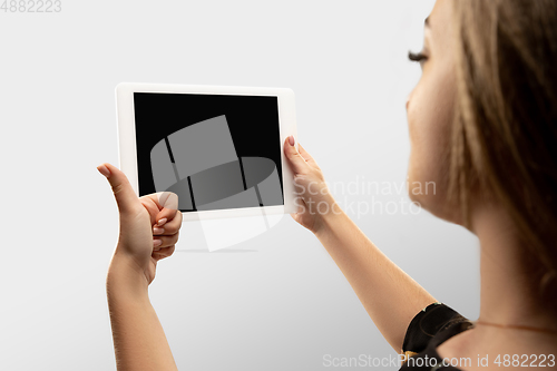 Image of Close up female hands holding tablet with blank screen during online watching of popular sport matches and championships all around the world. Copyspace for ad