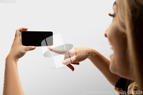 Image of Close up female hands holding smartphone with blank screen during online watching of popular sport matches and championships all around the world. Copyspace for ad