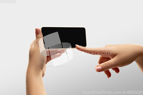 Image of Close up female hands holding smartphone with blank screen during online watching of popular sport matches and championships all around the world. Copyspace for ad