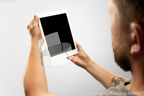 Image of Close up male hands holding tablet with blank screen during online watching of popular sport matches and championships all around the world. Copyspace for ad