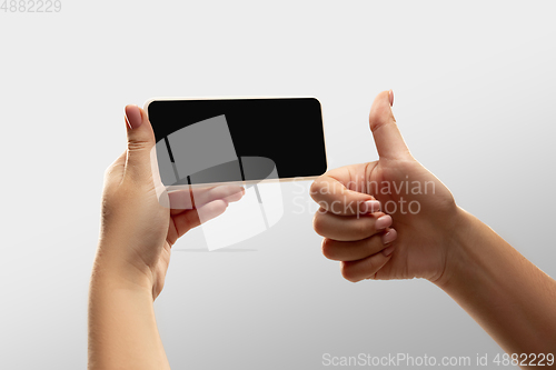 Image of Close up female hands holding smartphone with blank screen during online watching of popular sport matches and championships all around the world. Copyspace for ad