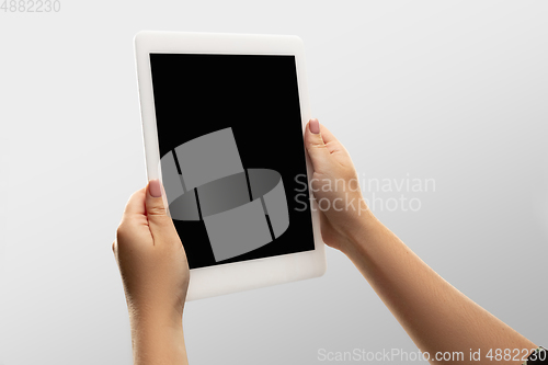 Image of Close up female hands holding tablet with blank screen during online watching of popular sport matches and championships all around the world. Copyspace for ad