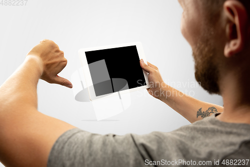 Image of Close up male hands holding tablet with blank screen during online watching of popular sport matches and championships all around the world. Copyspace for ad