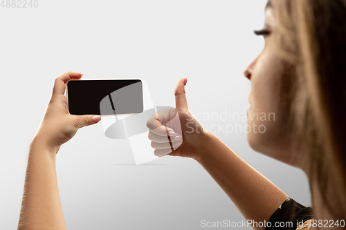 Image of Close up female hands holding smartphone with blank screen during online watching of popular sport matches and championships all around the world. Copyspace for ad