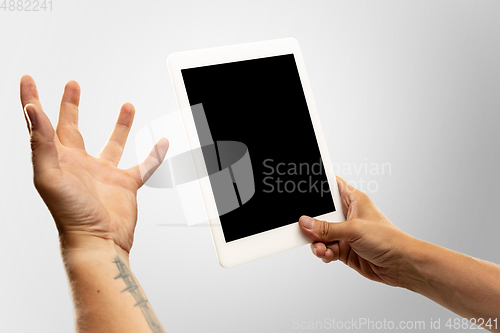 Image of Close up male hands holding tablet with blank screen during online watching of popular sport matches and championships all around the world. Copyspace for ad