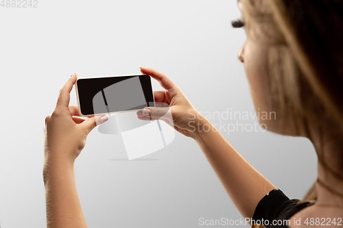 Image of Close up female hands holding smartphone with blank screen during online watching of popular sport matches and championships all around the world. Copyspace for ad