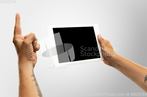 Image of Close up male hands holding tablet with blank screen during online watching of popular sport matches and championships all around the world. Copyspace for ad