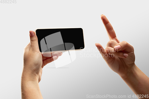 Image of Close up female hands holding smartphone with blank screen during online watching of popular sport matches and championships all around the world. Copyspace for ad