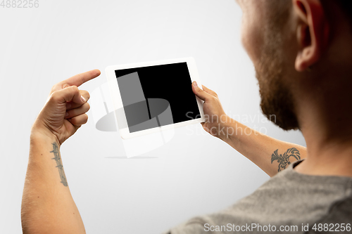 Image of Close up male hands holding tablet with blank screen during online watching of popular sport matches and championships all around the world. Copyspace for ad