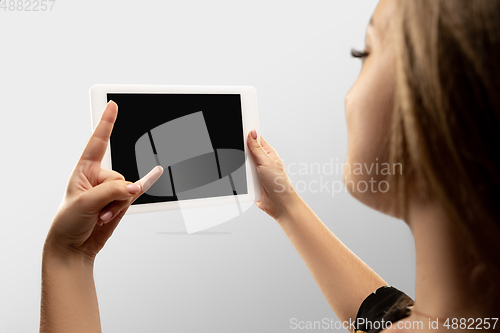 Image of Close up female hands holding tablet with blank screen during online watching of popular sport matches and championships all around the world. Copyspace for ad