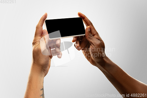 Image of Close up male hands holding phone with blank screen during online watching of popular sport matches and championships all around the world. Copyspace for ad