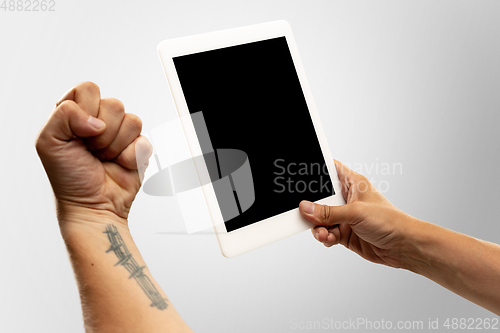 Image of Close up male hands holding tablet with blank screen during online watching of popular sport matches and championships all around the world. Copyspace for ad