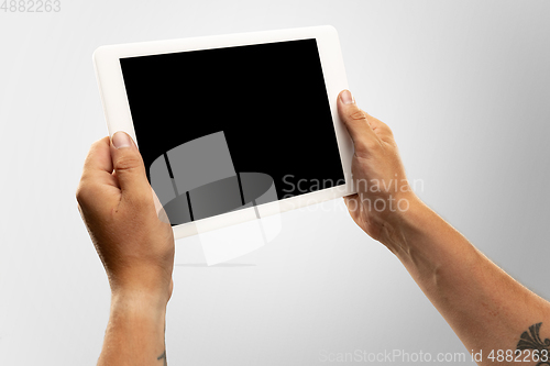 Image of Close up male hands holding tablet with blank screen during online watching of popular sport matches and championships all around the world. Copyspace for ad