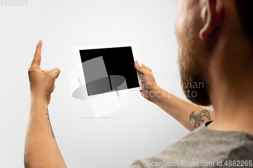 Image of Close up male hands holding tablet with blank screen during online watching of popular sport matches and championships all around the world. Copyspace for ad