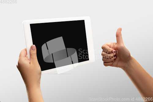 Image of Close up female hands holding tablet with blank screen during online watching of popular sport matches and championships all around the world. Copyspace for ad