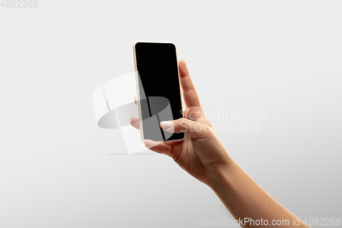 Image of Close up female hands holding smartphone with blank screen during online watching of popular sport matches and championships all around the world. Copyspace for ad