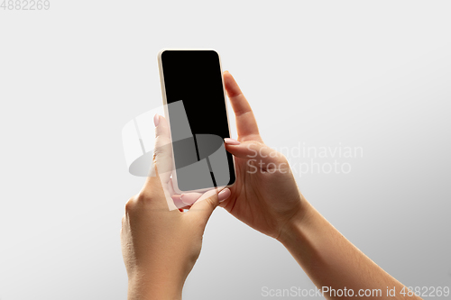 Image of Close up female hands holding smartphone with blank screen during online watching of popular sport matches and championships all around the world. Copyspace for ad