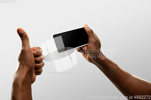 Image of Close up male hands holding smartphone with blank screen during online watching of popular sport matches and championships all around the world. Copyspace for ad