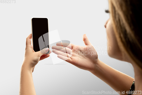 Image of Close up female hands holding smartphone with blank screen during online watching of popular sport matches and championships all around the world. Copyspace for ad