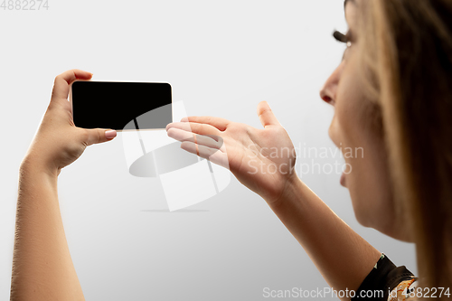 Image of Close up female hands holding smartphone with blank screen during online watching of popular sport matches and championships all around the world. Copyspace for ad