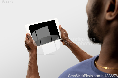 Image of Close up male hands holding tablet with blank screen during online watching of popular sport matches and championships all around the world. Copyspace for ad