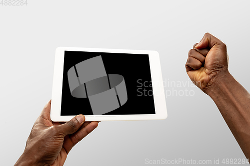 Image of Close up male hands holding tablet with blank screen during online watching of popular sport matches and championships all around the world. Copyspace for ad