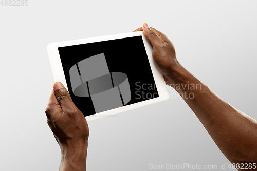 Image of Close up male hands holding tablet with blank screen during online watching of popular sport matches and championships all around the world. Copyspace for ad