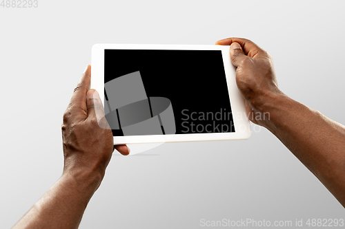 Image of Close up male hands holding tablet with blank screen during online watching of popular sport matches and championships all around the world. Copyspace for ad